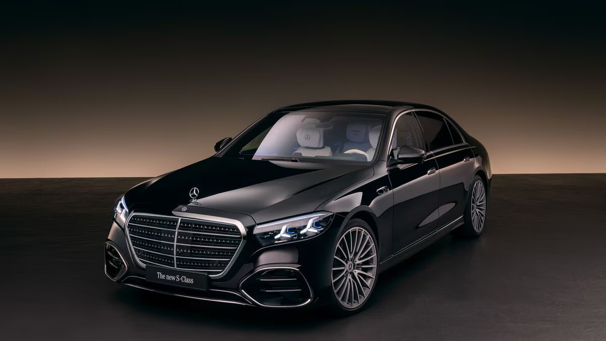 Black Mercedes-Benz S-Class in a warm studio setting with soft amber lighting
